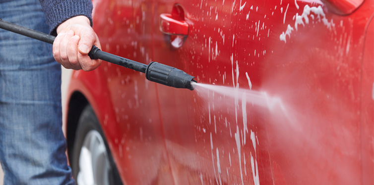 man washing car with pressure washer