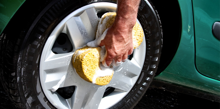 man washing the rim of his car