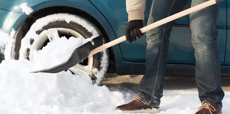man cleaning snow of his car