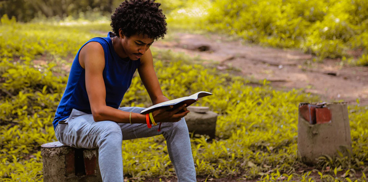 man sitting and reading a book