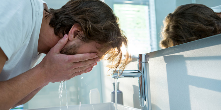 man washing his face