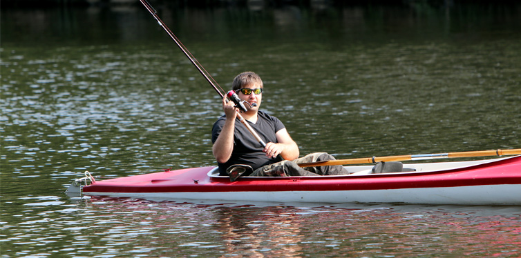 man fishing in red kayak