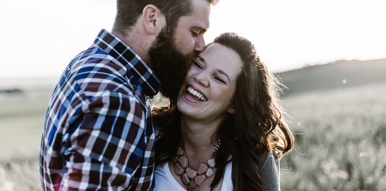 man kissing woman in grass area