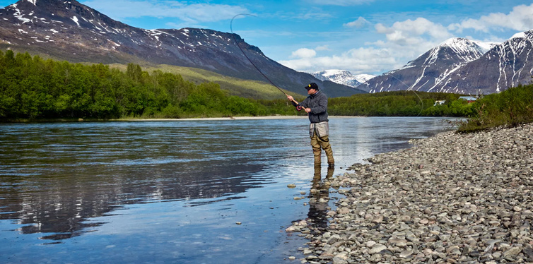 man on the river bank fishing