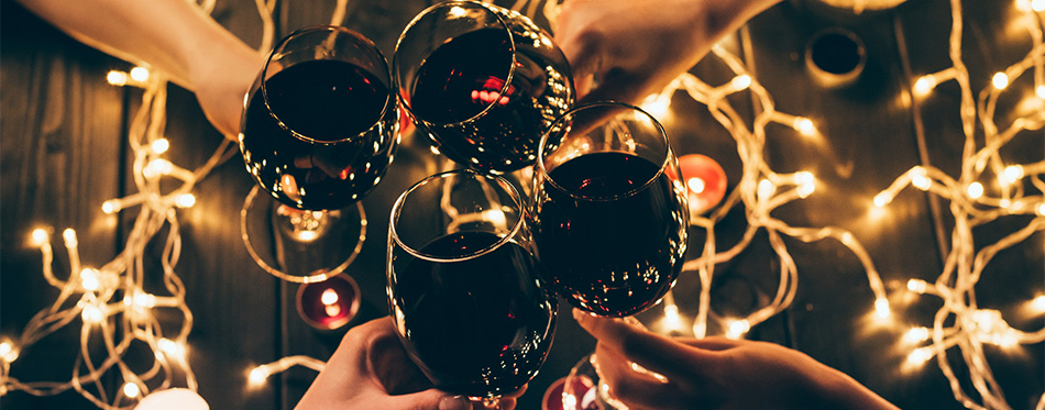 people clinking glasses over fairylights