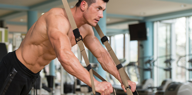 athletic man doing trx exercises