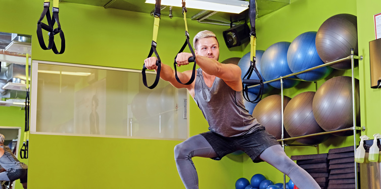 man doing trx workout at the gym