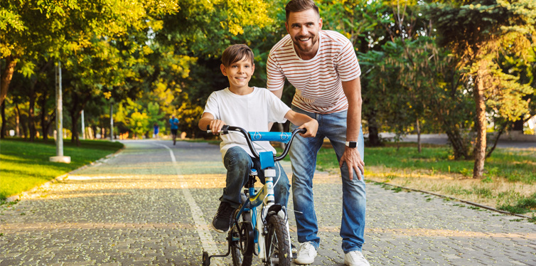 father teaching his son to ride a bike