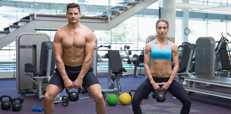 a couple doing squats in the gym