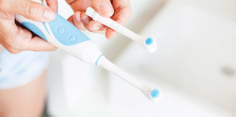 person holding electric toothbrush