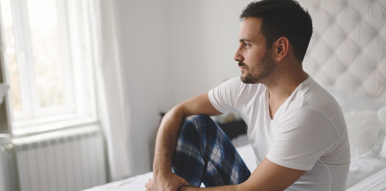 sad man sitting on the bed