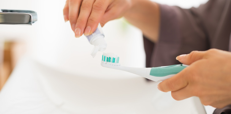 woman holding toothbrush and toothpaste