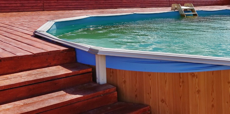 adult above ground frame swimming pool with wooden patio deck flooring
