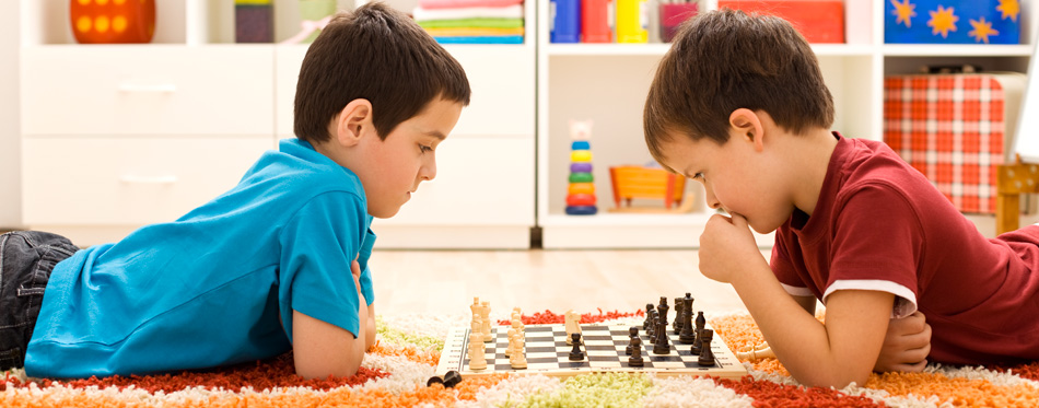 boys playing with a chess set for kids