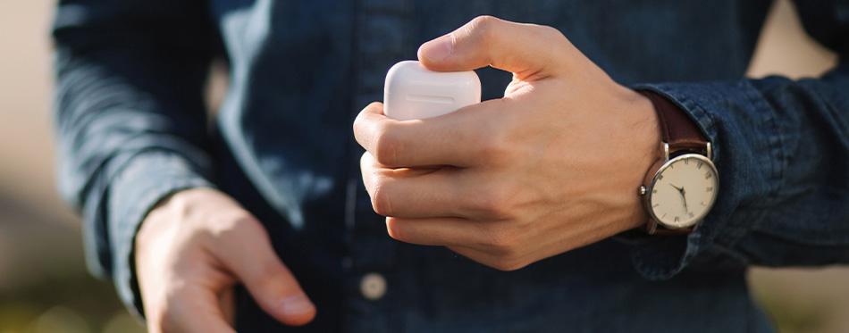 man holding earbuds case