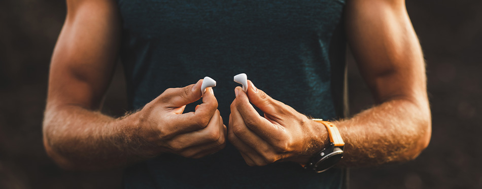 man holding earbuds