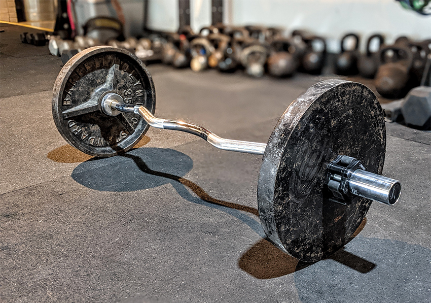ez curl bar and weights sitting on a gym floor