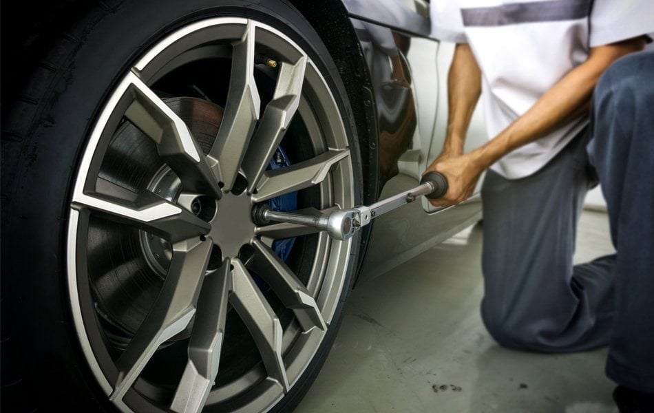 auto mechanic using torque wrench