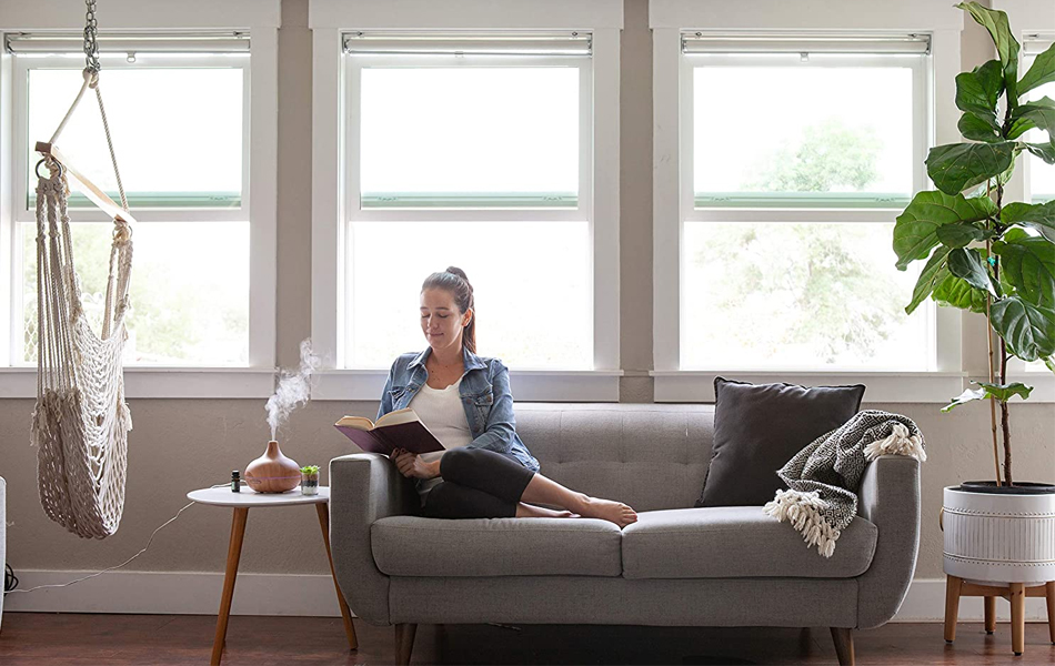 girl reading a book next to essential oil diffuser