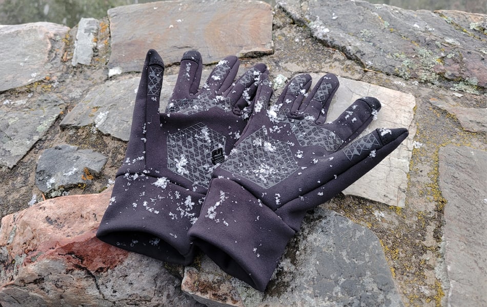 hiking gloves on a brick wall