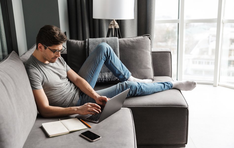 man in stretch jeans on the couch working