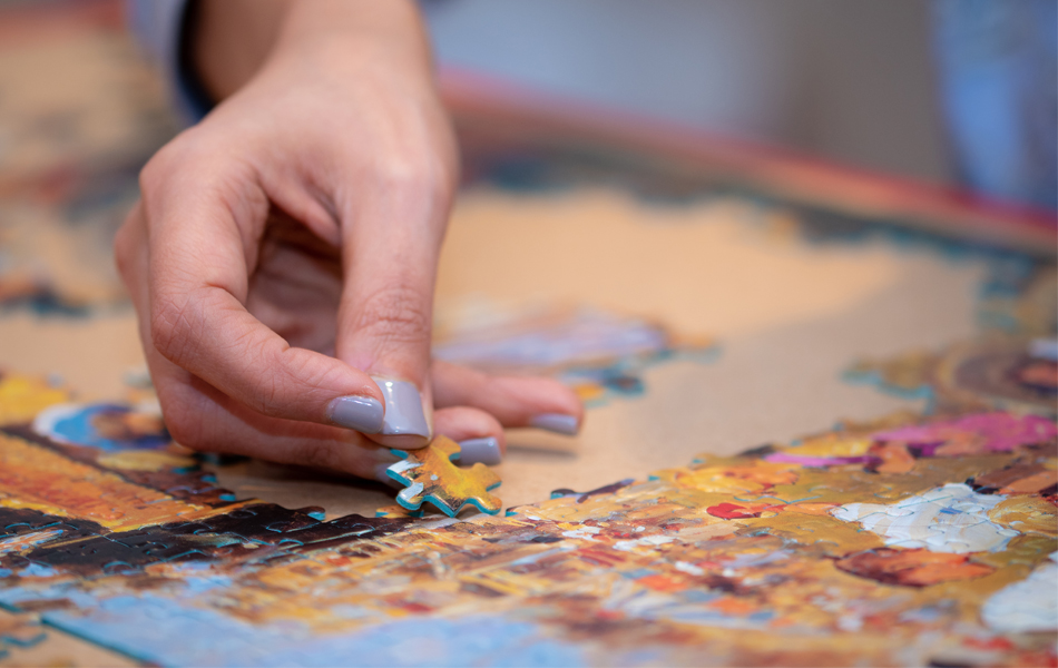 person solving a jigsaw puzzle