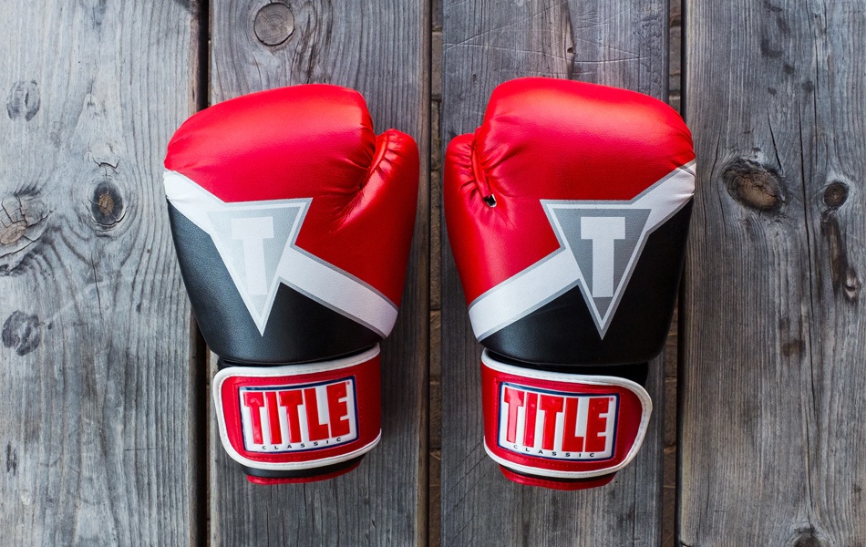 red boxing gloves on wooden surface