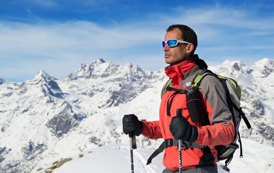 winter hiker in red jacket and blak hiking gloves