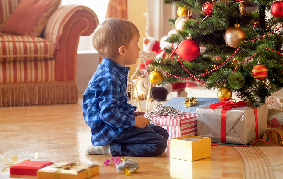 3 years old boy sitting under christmas tree