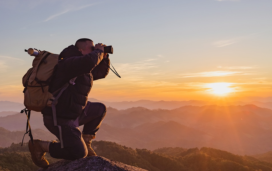 man with backpack and holding a binoculars
