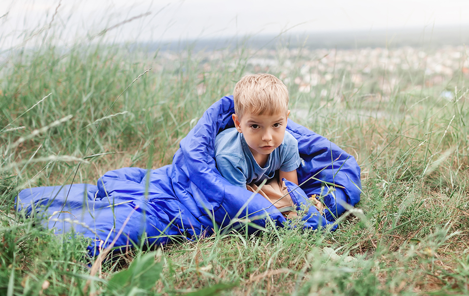 boy laying in kids sleeping bag