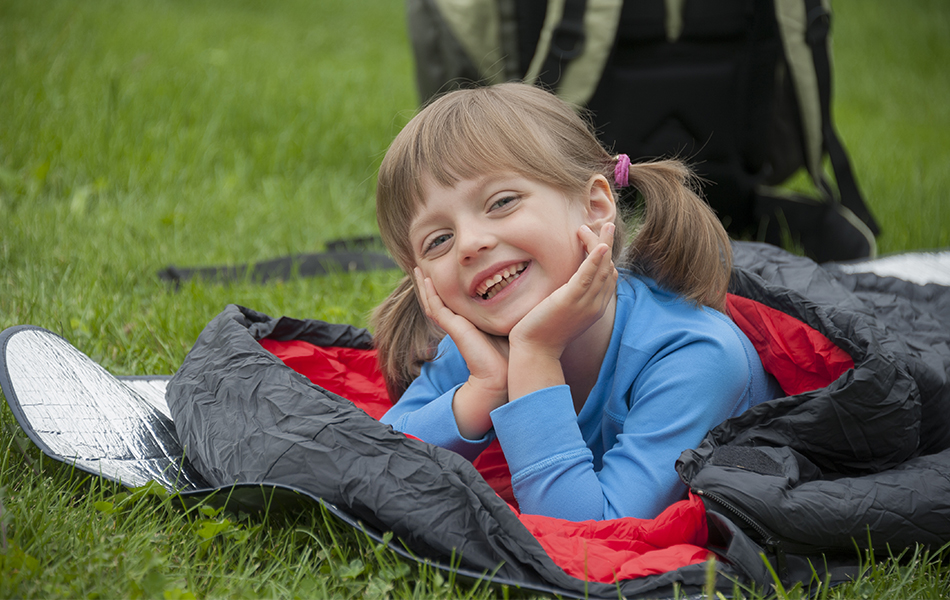 little girl camping with sleeping bag