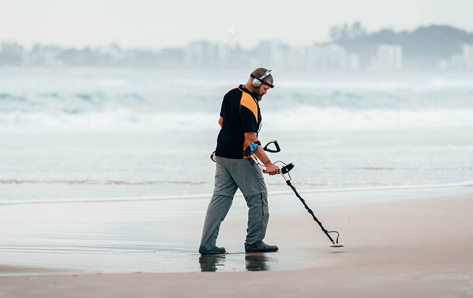 men with headphones using metal detector