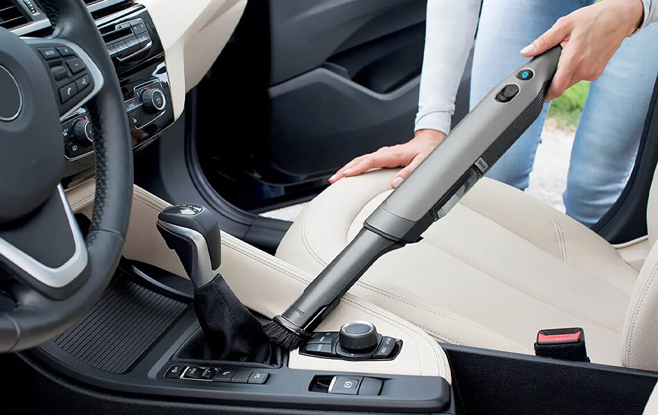 vacuuming the car with handheld vacuum