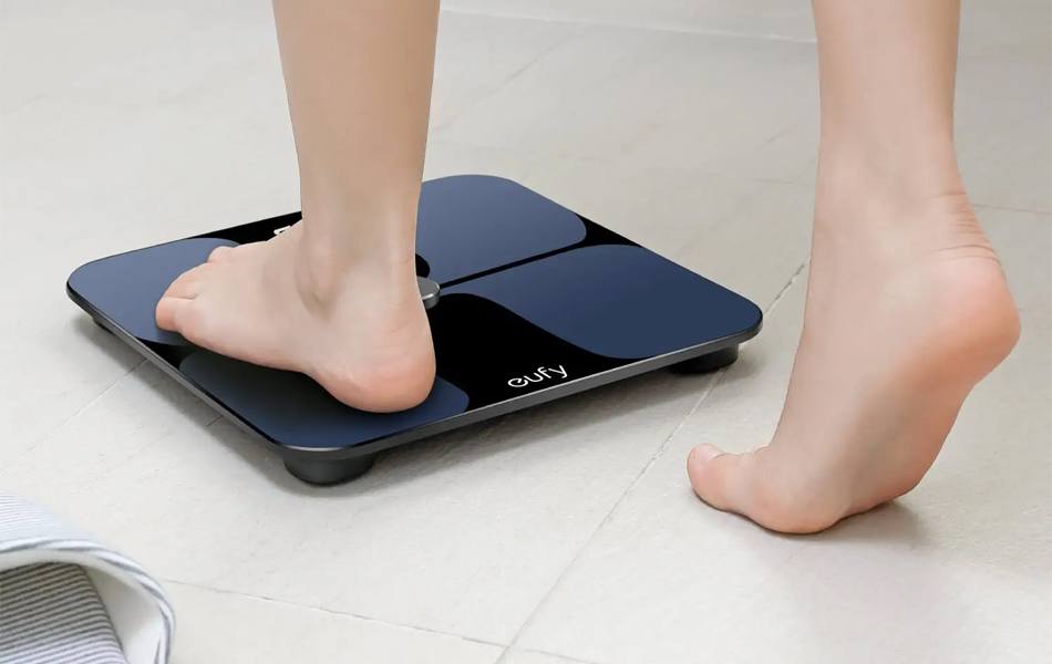 woman checking her weight on smart scale