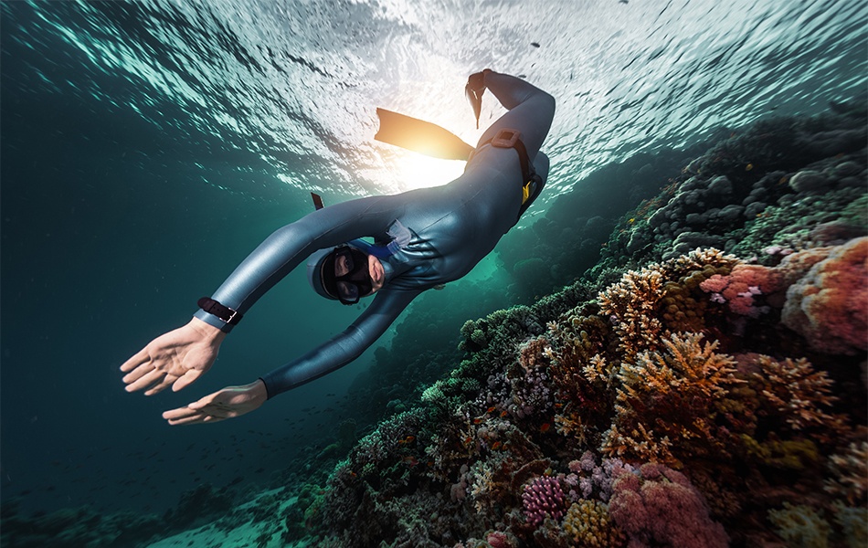 woman wearing freediving watch while diving in the ocean