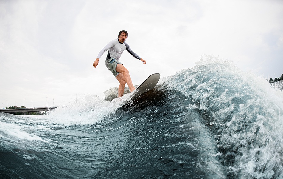 active sportsman balancing on wakesurf board