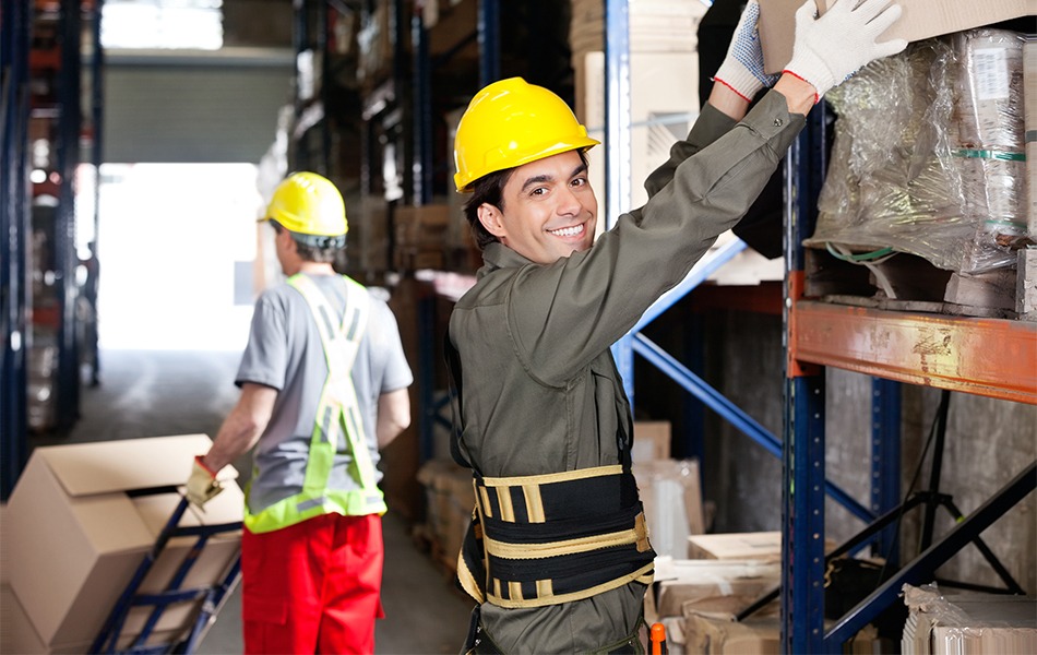 foreman lifting cardboard box while wearing back brace