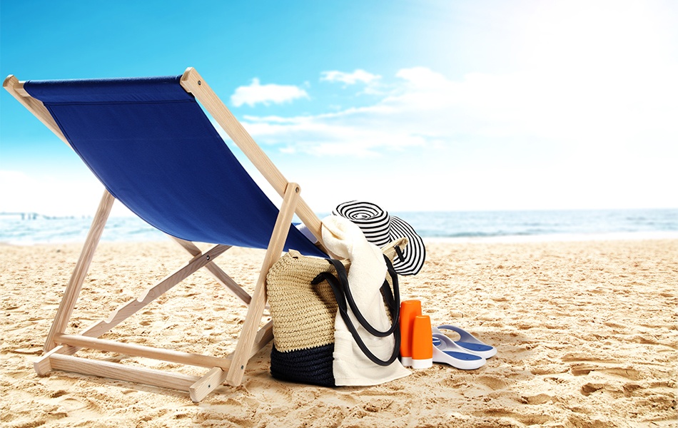 landscape of ocean with beach chair bag and hat