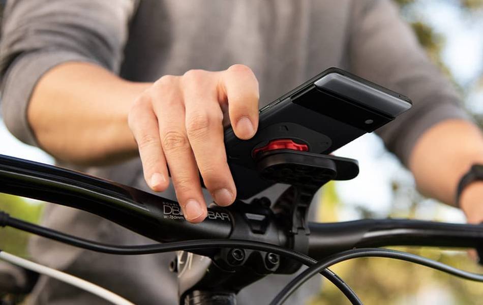 man placing his phone on the bike phone mount