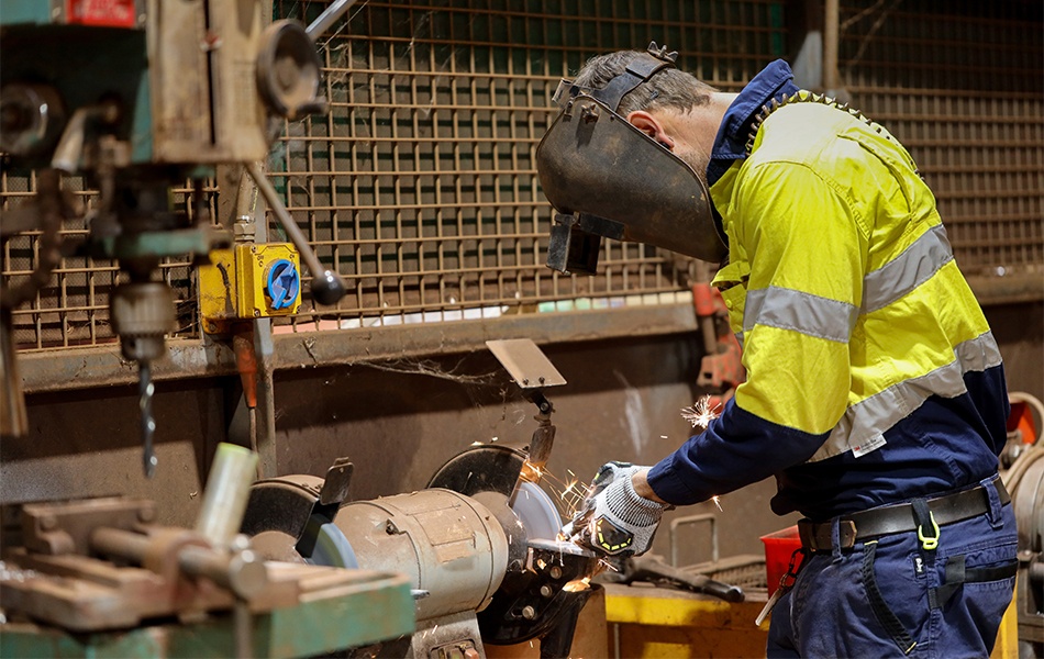 man using bench grinder