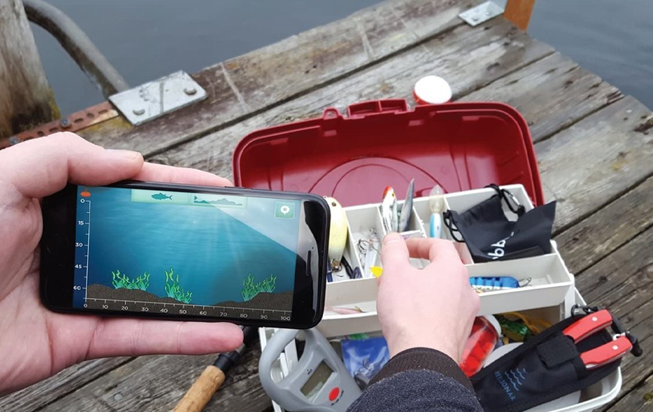 man using portable fish finder while fishing