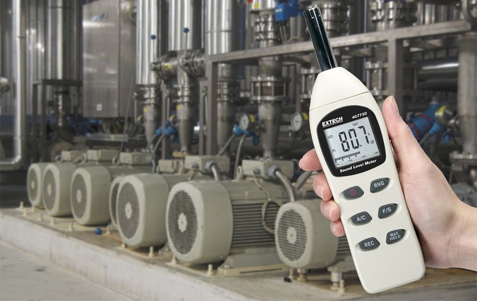 man using decibel meter on job site